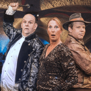 Werbefoto für die Das Krimidiner "Fluch des Kaiserschatzes" im Ingelheimer Winzerkeller. Das Foto zeigt zwei Männer und eine Frau im Gewölbekeller. Ein Mann trägt einen Hut, der andere hat eine Glatze. Die Frau hat rot Haare.