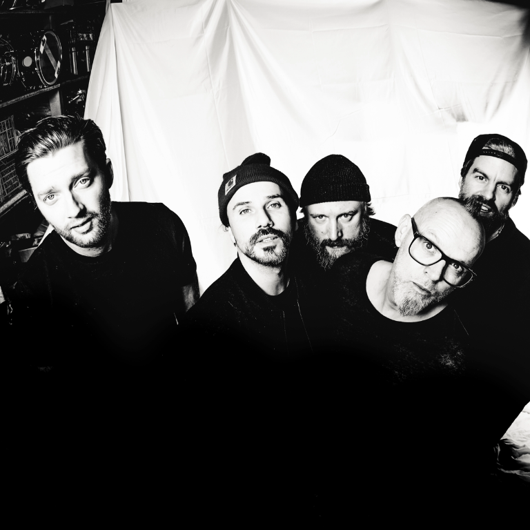 Thomas D im Vordergrund und The KBCS im HIntergrund schauen in die Kamera