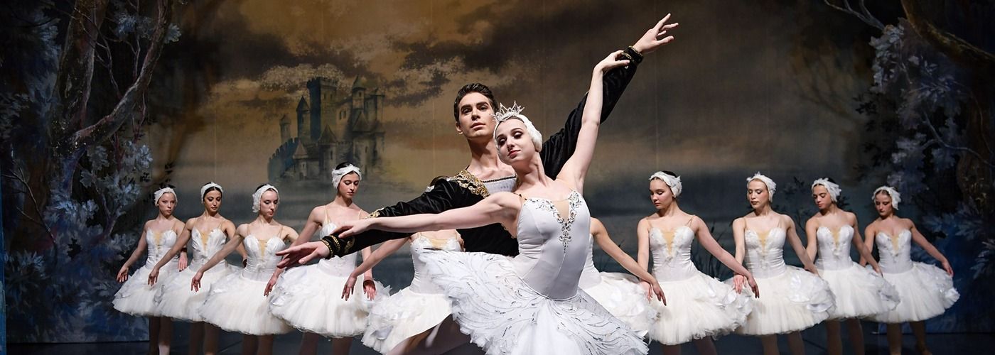 Ballettensemble des Classico Ballet Napoli in weißen Kostümen auf der Bühne bei Schwanensee.